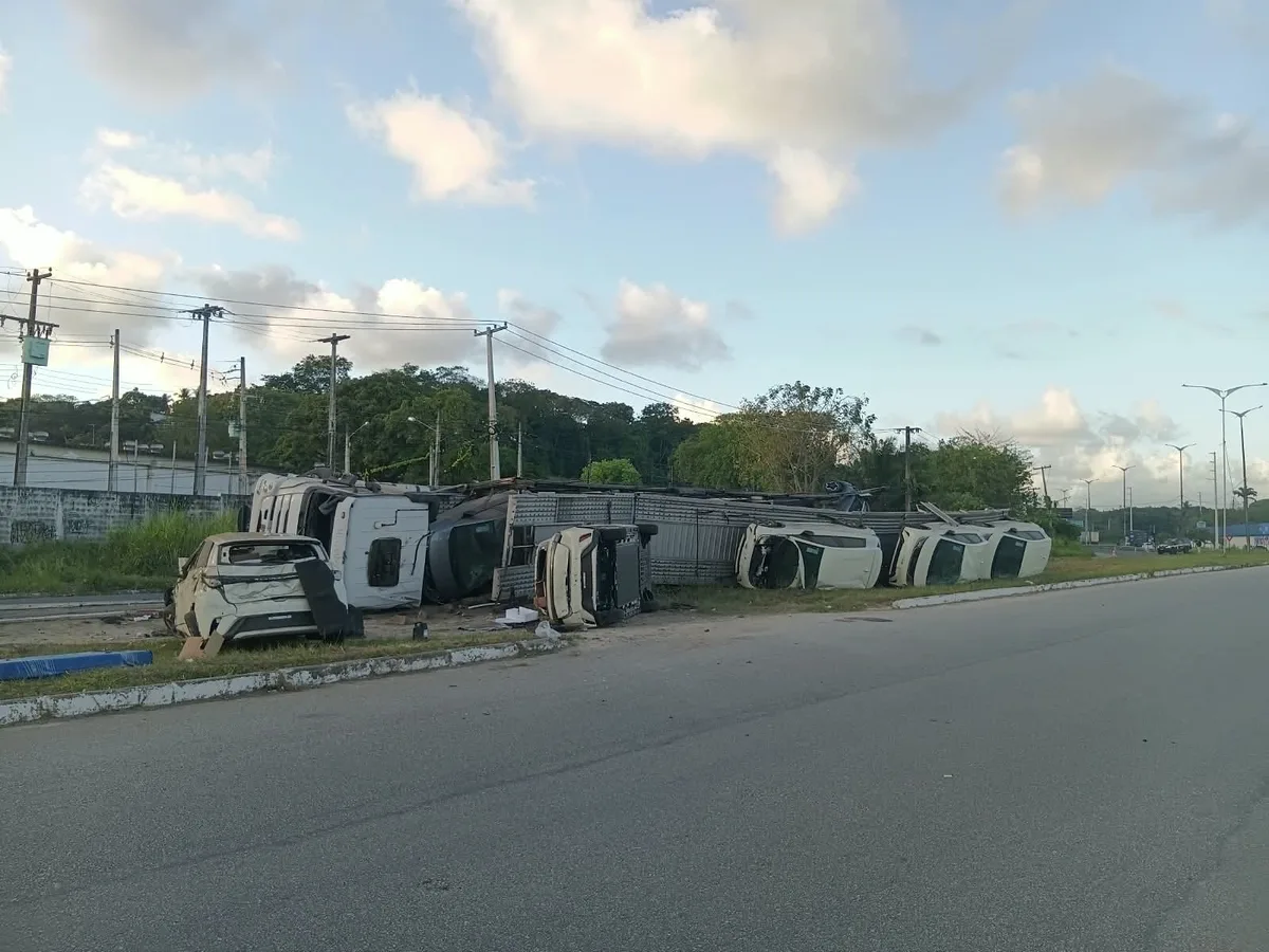 Caminhão-cegonha tomba e carros elétricos ficam espalhados no canteiro central da BR-101; VÍDEO