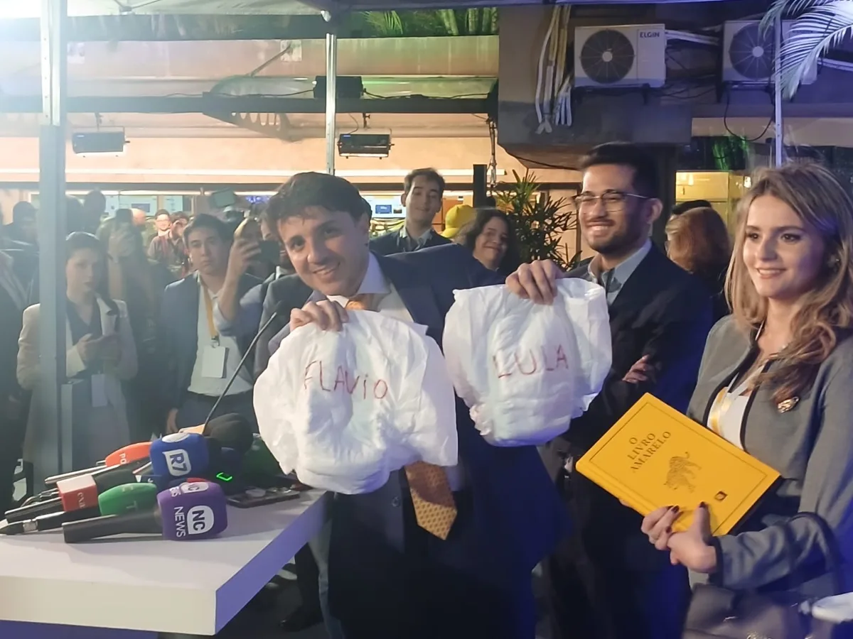 Em debate da Band, Renan Santos leva fraldas para Lula e Flávio Bolsonaro