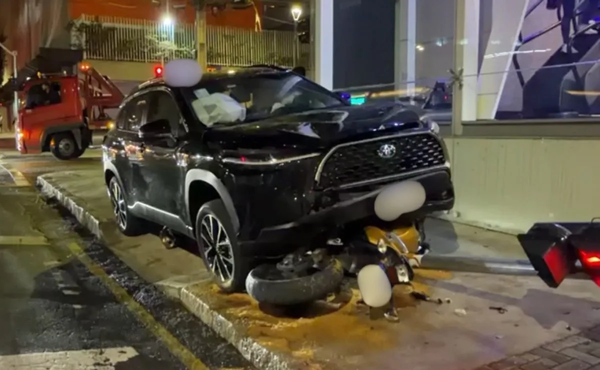 Motociclista de aplicativo bate contra SUV e moto para debaixo de veículo; duas pessoas ficam gravemente feridas em Curitiba