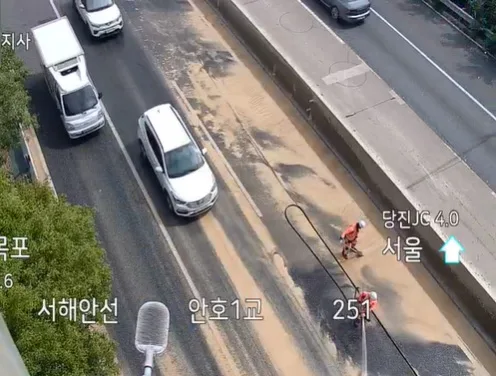 고속도로 달리던 덤프트럭서 탈황석고 쏟아져 도로 세척 작업