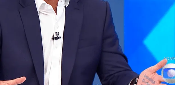 Flávio repete Bolsonaro e usa 'cola' na mão em sabatina no Jornal Nacional