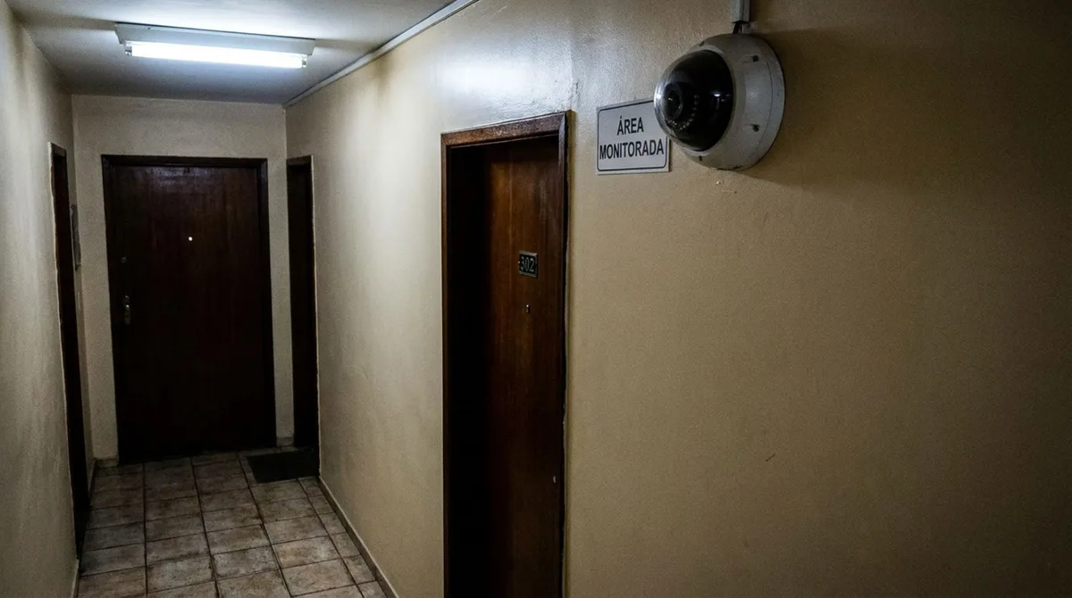 Moradora passa alguns dias fora e, ao voltar descobre que o condomínio instalou uma câmera no corredor, exatamente diante da porta de seu apartamento