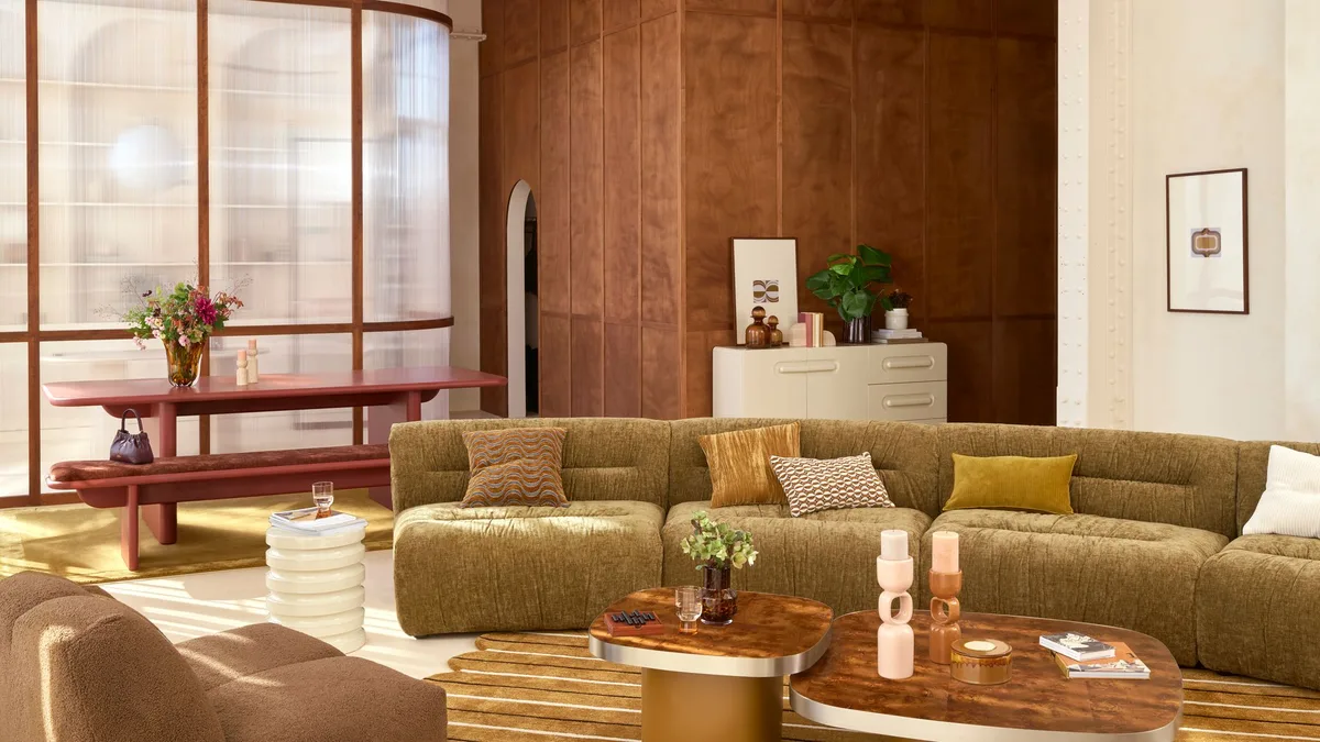 Los salones de 2026 recuperan la decoración de los años 70: sofás curvos, madera oscura y colores cálidos que vuelven a estar de moda