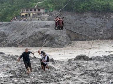 Trading food for medicine and crossing the river by zip line are part of life in Nepal flood zone