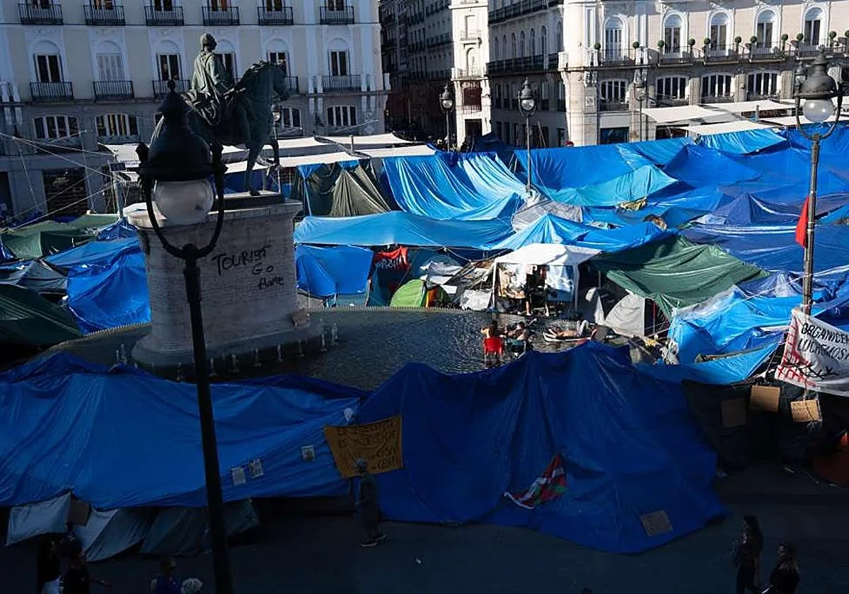 Los acampados en la Puerta del Sol utilizan la fuente de la plaza como piscina y se bañan con colchonetas