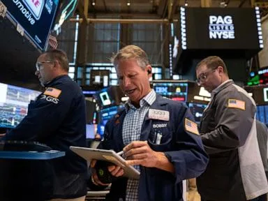 World shares are mostly lower after Wall St retreats following economic updates